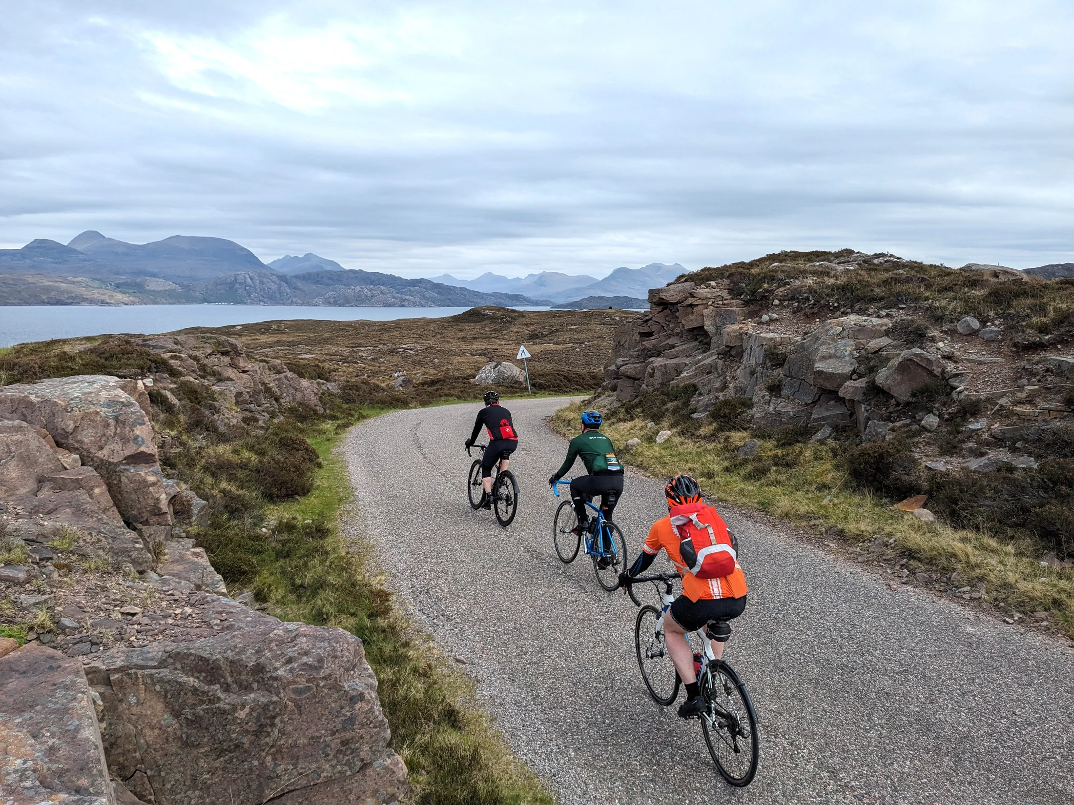 Out Velo riders cycling a remote road in the Scottish Highlands